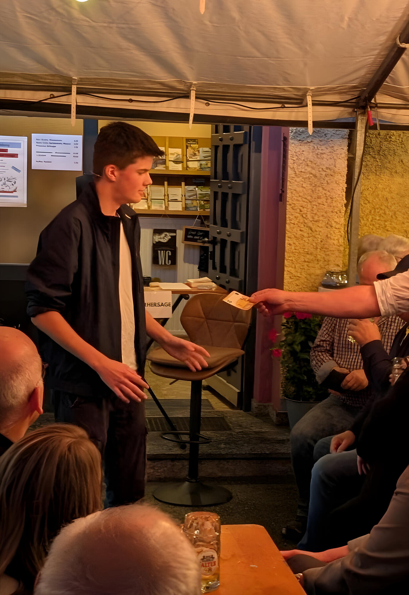 Der Zauberer Anton Amberger bei einer Bühnenshow, bei dem er gerade ein Kunststück vorführt, bei der sich Geld vermehrt.